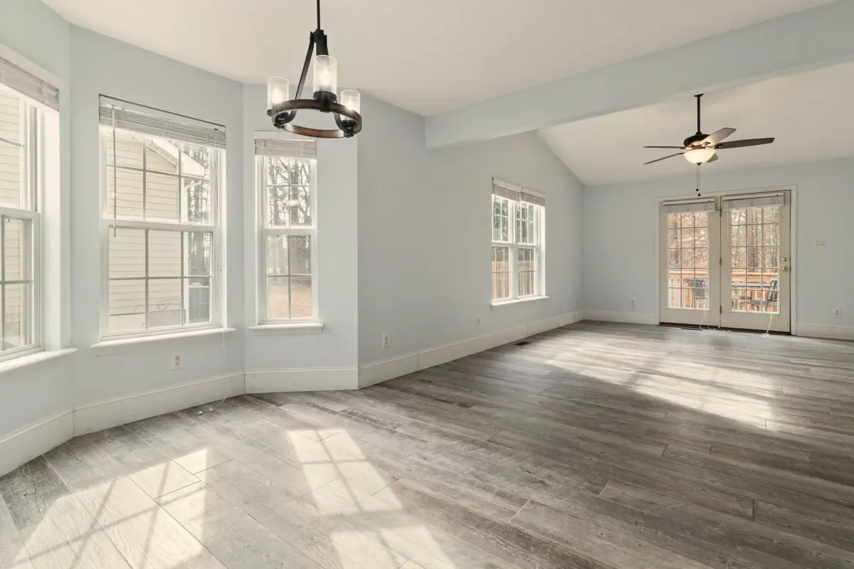 An empty bright room with a bay window and timber floors