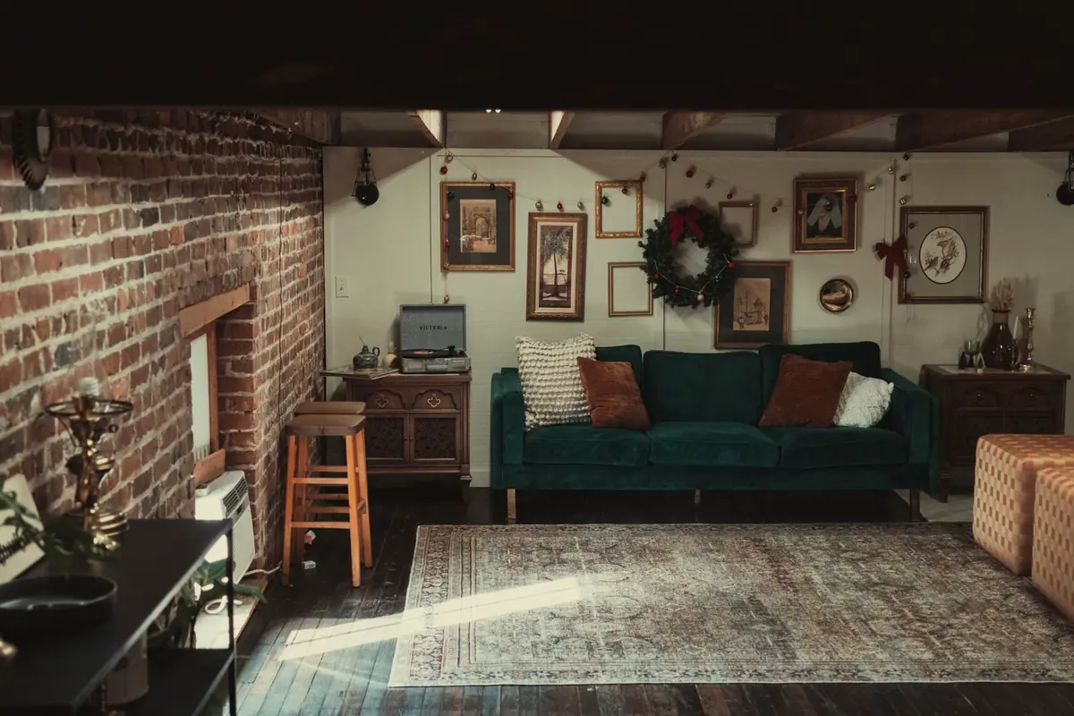 A lounge with a brick wall, a sofa and framed art