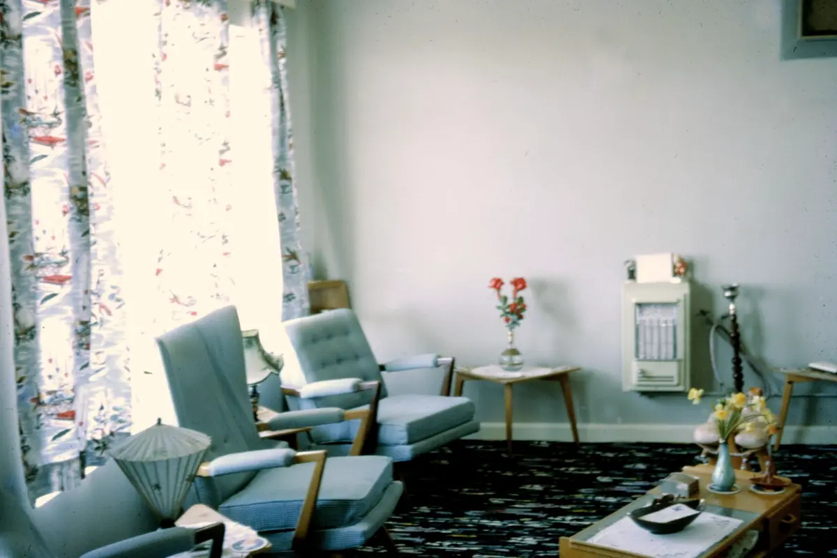 A lounge with mid century furniture and patterned curtains
